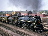 CNR U2e Northern 6167 operates on a UCRS fantrip from Toronto to Picton, shown in Belleville yard on August 26th, 1962 with excursion goers leaning out of the open doorways of the baggage car immediately behind.