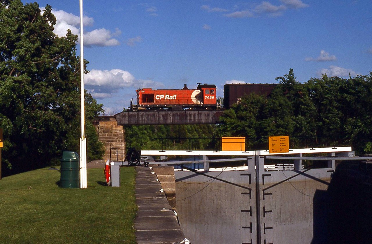 1945-built CP Rail Alco S2 7028 crosses above the Rideau Canal locks at Smiths Falls Ontario, around Mile 1 of the CP Brockville Sub, returning from Brockville.