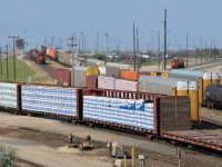 <b>A busy hump yard.</b> A hump set consisting of two hump 'mother' units sandwiching two hump booster units (CN 7522, CN 523, CN 515 & CN 7511) is seen on the busy hump at Symington Yard at left. At right is another set led by CN 7500.