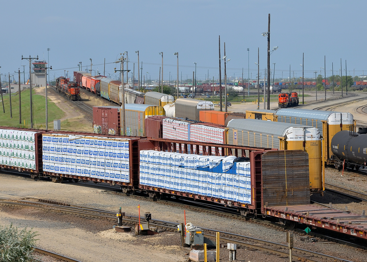 A busy hump yard. A hump set consisting of two hump 'mother' units sandwiching two hump booster units (CN 7522, CN 523, CN 515 & CN 7511) is seen on the busy hump at Symington Yard at left. At right is another set led by CN 7500.