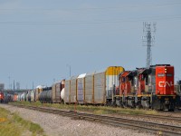 <b>A trio of SD40U's in hump service.</b> A trio of SD40U's, along with a slug (CN 6015, CN 6005, CN 6012 and CN 225) pause from their hump yard duties at the east end of Symington Yard. At left in the distance CN 438 gets ready to leave with CN 3047 leading.