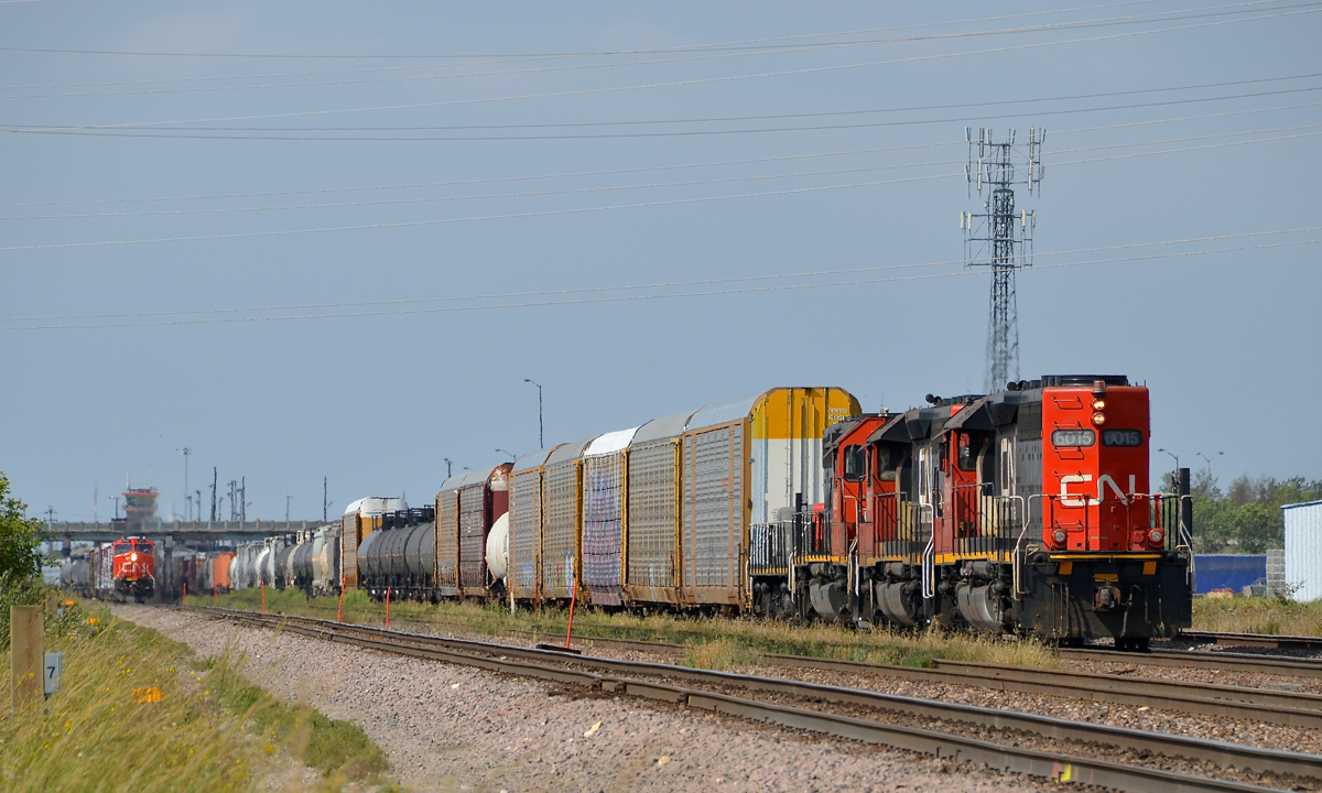 A trio of SD40U's in hump service. A trio of SD40U's, along with a slug (CN 6015, CN 6005, CN 6012 and CN 225) pause from their hump yard duties at the east end of Symington Yard. At left in the distance CN 438 gets ready to leave with CN 3047 leading.