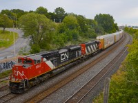 <b>A clean SD70M-2 leader in the rain.</b> As the rain starts to fall, clean CN 8947 leads CN 401 through Montreal West, with CN 9486 trailing.