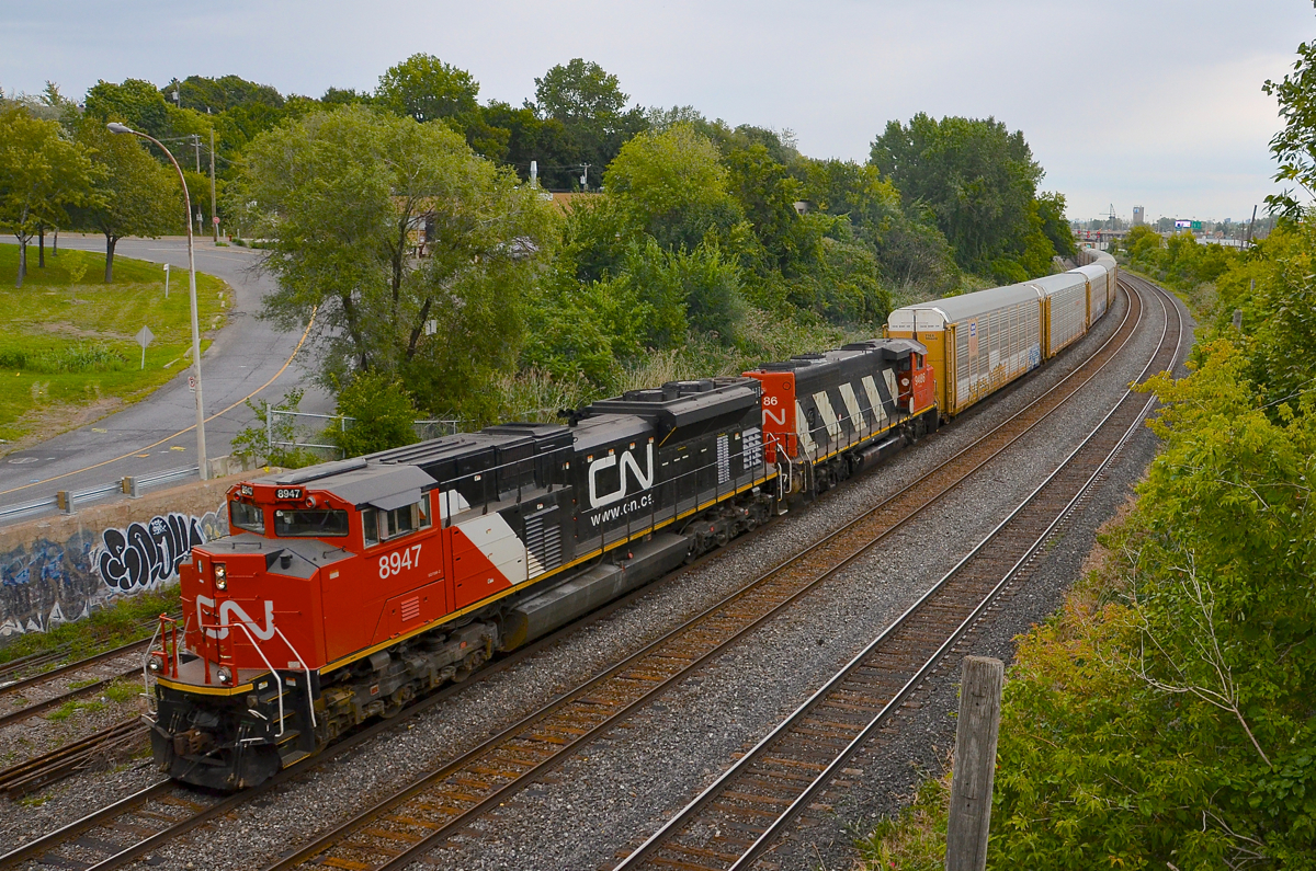 A clean SD70M-2 leader in the rain. As the rain starts to fall, clean CN 8947 leads CN 401 through Montreal West, with CN 9486 trailing.