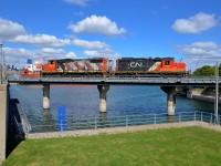 CN 4810 & CN 7075 are heading light into the Port of Montreal to pick up some cars as they cross the eastern end of the Lachine Canal. At left can be seen the superstructure of the bulk carrier <i>Venture</i>, which has been in the port all summer long.