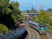 <b>Zooming past a slow freight train.</b> VIA 69 is on the north track of CN's Montreal Sub as it zooms by local transfer CN 527, which is slowly heading west as well on the transfer track. 