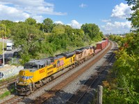 <b>Two different shades of armour yellow.</b> In a break from the usual black NS power, CN 529 has a pair of UP units as it heads through Montreal West with a short train. Leading is fairly fresh SD70Ace UP 8822 (built in 2013) while the older trailing unit (ES44AC UP 5335, built in 2006) has a much more faded version of the classic armour yellow paint scheme.