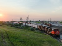 CN 8884 & CN 5613 lead an eastbound out of Symington Yard close to sunset. At right is the hump, with two hump sets working.