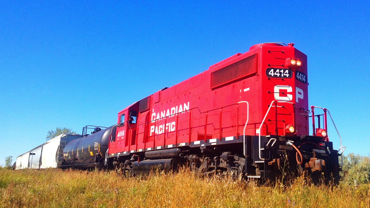 Long hood forward CP 4414 hauls a 6-pack of cars east on the Oak Point Spur in Winnipeg near King Edward Street. This track used to be part of the CN Oak Point Subdivision, which CN abandoned in 1996. 2.7 miles in the city survived, and CP uses it to serve a few industries in northwestern Winnipeg. Although CP serves it, it still has CN stickers on the crossings. A crossing was replaced recently, and it was given CN Oak Point Sub stickers. Go figure.