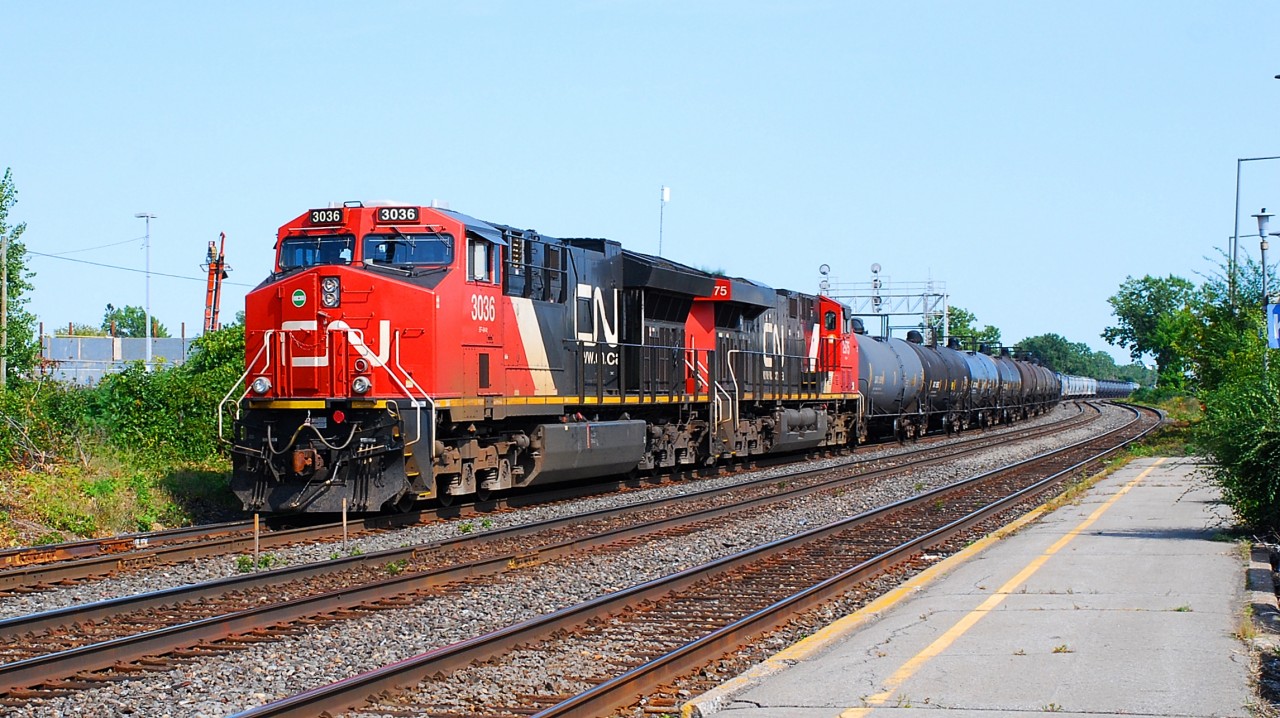 CN-3036 a EF-644T leading with CN-2975 a EF-644R pulling tanks cars and other freight cars  on rte.377