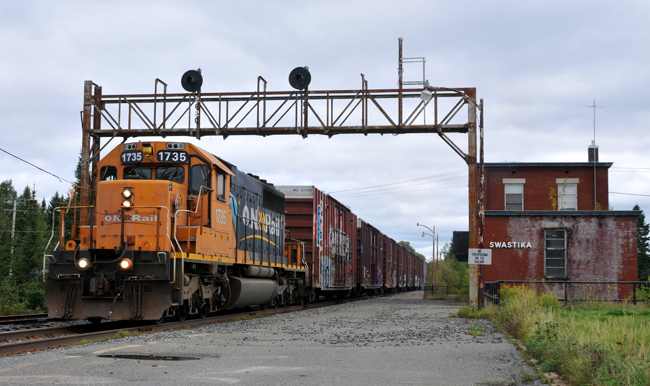213 passing by the abandoned Swastika station with SD40-2 #1735 in charge of 55 cars
