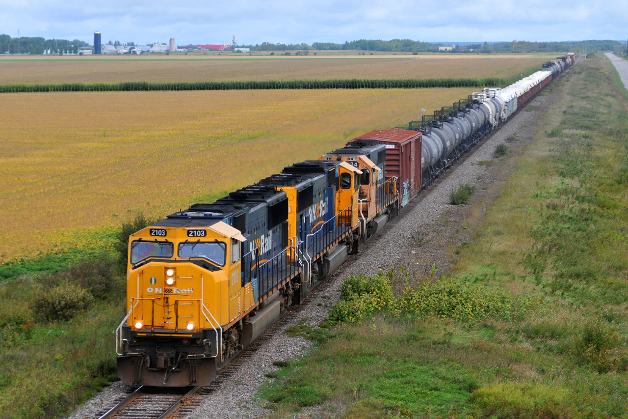 Minutes after departing Englehart, 214 passes through Earlton with ONT 2103 - ONT 2101 - ONT 1734 and 67 cars destined for North Bay