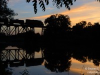 Vacation's over - time to post some photos. Caption: Still waters of the Conestogo river reflect a yellow and orange sunset, and a train: GEXR 584 with tank cars are northbound for Chemtura in Elmira. Mosquitos were biting every square inch of exposed skin as I took this photo, and it was more than worth it. 
