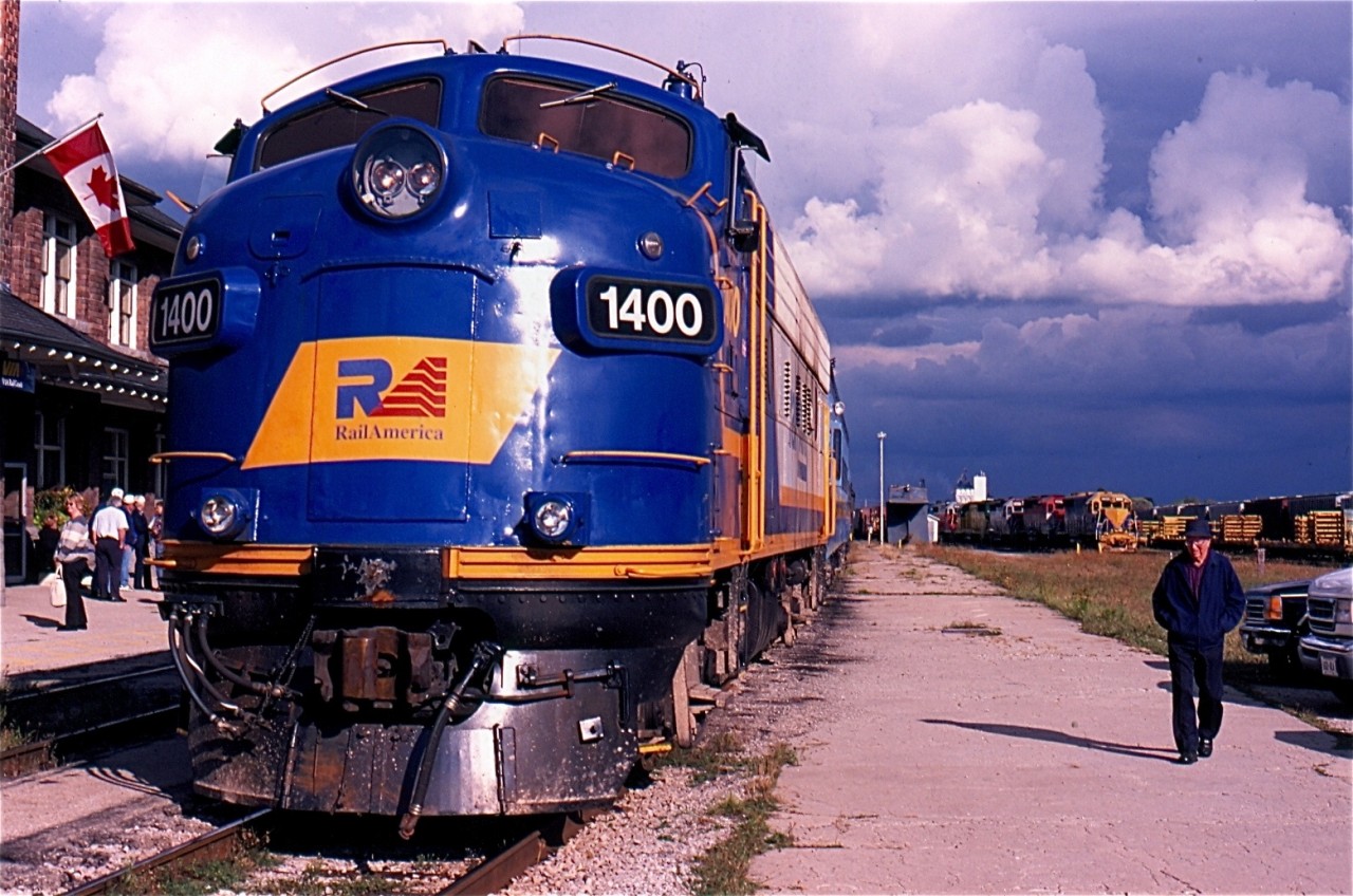 The year 2003 was a busy one for Essex Terminal steam engine #9. The old engine spent a fair amount of time stretching its legs across Southern Ontario. In October it spent the better part of a week operating over the various lines operated by the Goderich -Exeter RR. It's companion for these trips was recently transferred Railink FP9 #1400. This day the fan trips operated between Stratford and St. Mary's. The train has just returned from St Mary's and is unloading its passengers when the sun briefly breaks through the mainly cloudy skies. In the background GEXR road train 431 has just arrived from Toronto with a rainbow consist of four axle Geeps. This would turn out to be the high point for FP9 #1400 during its life on the GEXR with its remaining years spent hauling loaded salt and grain trains out of Goderich until it and sister 1401 were retired and gradually stripped of usable parts to keep GEXR's lone surviving GP9 in service. The Ontario Southland would eventually rescue both 1400 & 1401 from a scrapper and today both are out on the road serving the OSR.