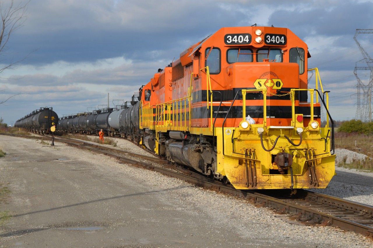 Two appropriately coloured pumpkins at Garnet on Halloween ... trick n treat for me.  RLHH 3404 and RLHH 3403 have been busy with switching duties at Garnet Yard for most of the afternoon.  The conductor seen here is about to cut the power away from a large string of tank cars and then proceed light power further south to the old CN Cayuga Subdivision and its connecting link to do additional switching involving a 'full' track of stored tank cars. The little white rectangle deep in the marshaling yard, to the left of the main, is actually the sign post CN Garnet MP 4.7 The next action for the orange n black locos was captured and submitted by Joe Bishop, fellow contributor, photo #26737. RLHH 595 was assigned as the symbol given the train being assembled at this point will eventually head south to Nanticoke.