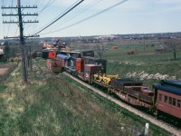 A few weeks ago I posted a photo of a CN westbound passenger and one of the Turbo train detouring on CP's Belleville Sub. at Bowmanville. Here we see the reason why as two CN 'big hooks' are working on a derailment about a mile east of Bowmanville which blocked both CN main liines. This view is looking west from just west of Bennet Road. The locomotive on the east end hook was 5553 and the Toronto hook working on the other end of the mess had 4563 and 4011 for power.