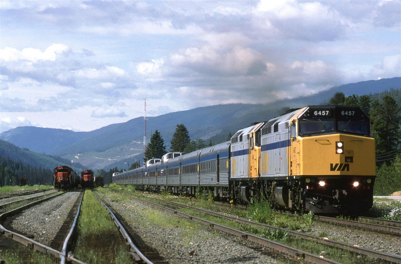 VIA made a quick stop in Blue River and then accelerated out of town. Two CN eastbound trains wait in the yard for crews or the signal to leave.