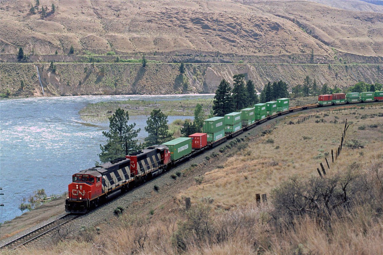 An eastbound double stack train swings through the big curve in Juniper Beach Provincial Park. The campground is in that grove of trees just above the rail cars. It is not a place for peace and quiet. Cn has a level crossing that they have to signal for and CP runs on the hill above the park across the North Thompson River. Otherwise, it is a nice little park, that seems to be expanding its boundaries over the years.