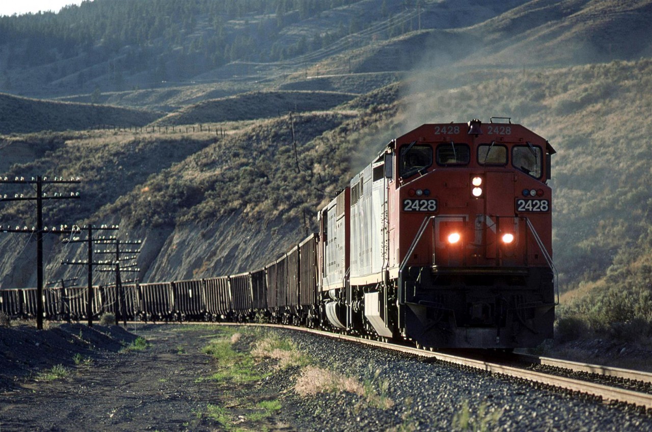 An eastbound empty coal train comes around a corner just east of the McAbee siding and Gravel pit.
The Trans Canada Highway may be seen well above the train.