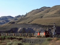 The first train after sun-up is a westbound coal led by a couple Cowled GE's. 
CP's line is clearly visible above this train.