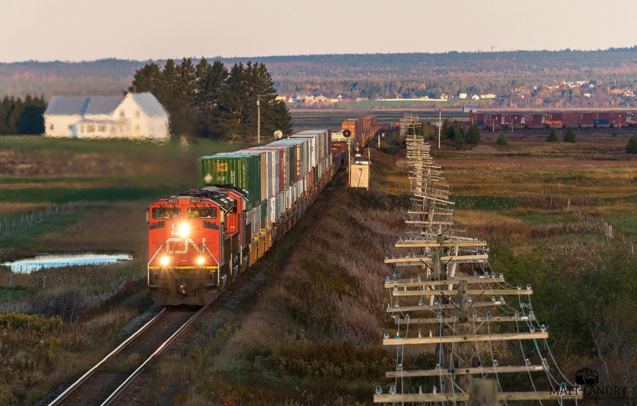 With the sun on the rise, CN 8833 leads stacker train Q120 as they cross the New Brunswick/Nova Scotia border on a chilly Fall morning.