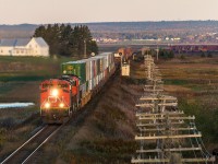 With the sun on the rise, CN 8833 leads stacker train Q120 as they cross the New Brunswick/Nova Scotia border on a chilly Fall morning. 