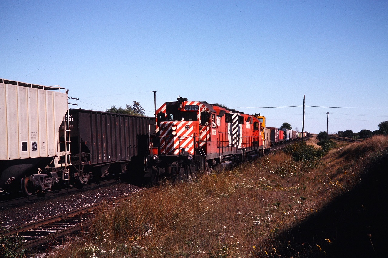 The Cobourg turn creeps along the siding as an eastbound train rolls by on the main. Photo by my brother.