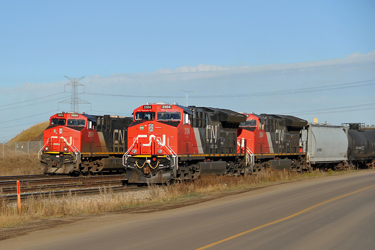 A pair of new ET44AC's CN 3104 and 3084 depart Clover Bar Yard with a full train of oil tank cars.  They will head down the Camrose sub for about three miles then enter the Kinda Morgan Terminal to be loaded.  In the background ES44AC CN 2869 will cross the North Saskatchewan River and head towards Edmonton.