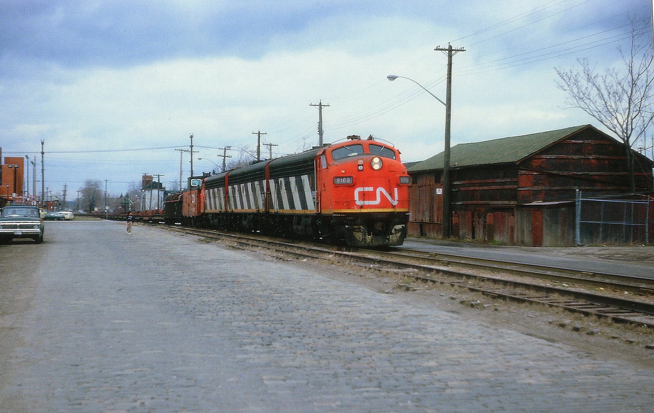 Here is another view from way back when the Nanticoke Steel train ran thru the bowels of Hamilton. This shot is taken a day later than a shot previously posted. Power is CN 9619, 9196 and 9172; and the train is just crossing Barton St and the ratty pavement is old Ferguson Av. Not all that scenic, but this IS downtown Hambone, so beauty was not to be expected. On the extreme left is the Hamilton detention centre, or, as we know it, the Barton Street Jail.