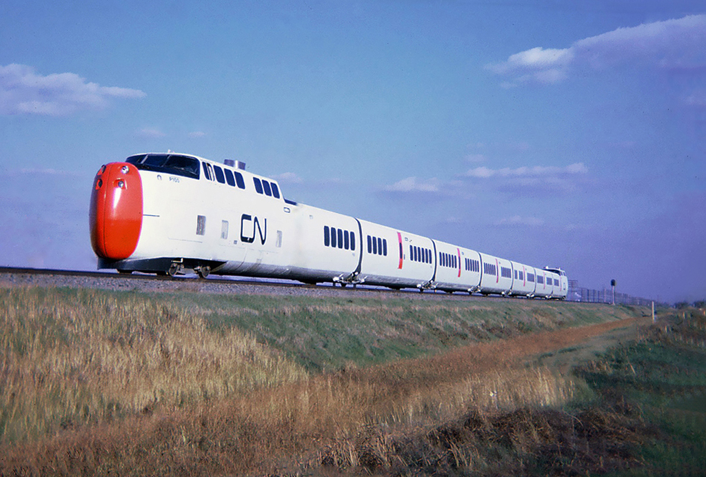 CNs new United Aircraft Turbo-Train flashes by almost silently. Although loved by many, these trains were plagued by mechanical problems and were withdrawn from service for the final time in 1982. Photo at Beaconsfield, Quebec May 09, 1968.