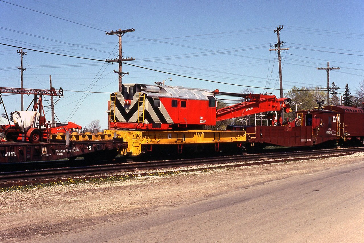 CN's Toronto Auxiliary is seen passing through Paris Junction enroute to assist in cleanup of a wreck further west. Here we see the auxiliary's "Big Hook" in consist: CN 50397, a 1957-built 250-ton Industrial Brownhoist wrecking crane, and the biggest of the big when it came to rail cranes. Note the CN employees riding its boom idler/tool car. At last check, 50397 was still on the roster but noted as being for sale.

The wreck the Toronto Auxiliary was heading to was the same wreck that the London Auxiliary was also heading to, pictured passing through Woodstock here: http://www.railpictures.ca/?attachment_id=25965