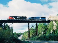    CN EMD SD75I 5751 and CSX SD50 8667 former Conrail 6757, on the Montreal-Halifax mainline with eastbound 148 intermodal train crossing a high trestle at milepost 60.6 on the Pelletier Sub., September 29, 2001.