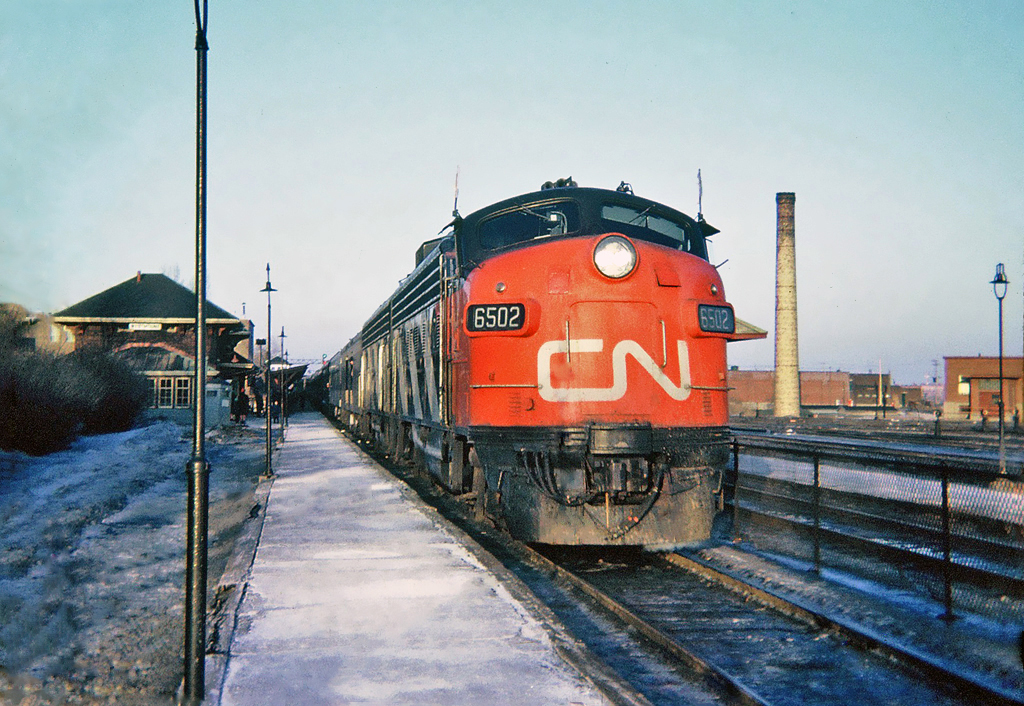 Westbound at Canadian Pacific's Westmount Station in December 1964 is the late afternoon pool train with their mix of CN and CP cars, The International Limited bound for Toronto. In charge today is CN's FP9 6502 and F9B 6610.