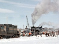 Canadian National Northern 6167, on a winter UCRS steam excursion from Toronto to Lindsay and back, pauses at Lindsay as a clamshell-equipped crane loads her tender with coal. This was a frequent occurrence on steam fantrips in the diesel era when there were no steam facilities around, or they had all been removed. Fantrip riders, railfans and spectators crowd around her, with some climbing on nearby CN GP9 4401 to have a look in her cab (but she recieves little attention compared to the star of the show, 6167).<br><br><i><b>More 6167 excursion photos:</i></b><br>Crew lubricating her running gear at Lindsay: <a href=http://www.railpictures.ca/?attachment_id=17715><b>http://www.railpictures.ca/?attachment_id=17715</b></a><br>On a UCRS excursion near the Humber River in Etobicoke: <a href=http://www.railpictures.ca/?attachment_id=25751><b>http://www.railpictures.ca/?attachment_id=25751</b></a><br>To Picton/Prince Edward County: <a href=http://www.railpictures.ca/?attachment_id=14252><b>http://www.railpictures.ca/?attachment_id=14252</b></a><br>Final 6167 fantrip, with 6218: <a href=http://www.railpictures.ca/?attachment_id=14528><b>http://www.railpictures.ca/?attachment_id=14528</b></a>