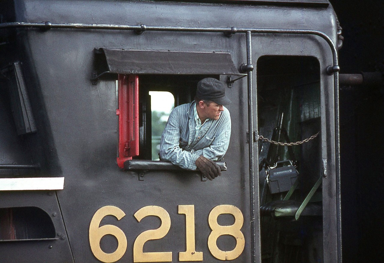 CN Northern 6218's fireman leans out of the cab window of his steed, keeping a watchful eye on the goings-on during a steam fantrip stop at Harrisburg, in September 1970.