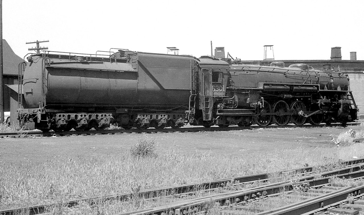 Canadian National 4-8-4 Northern 6301 (U3a class, built by Alco in Schenectady for GTR but transferred to CN) is seen here at Mimico Roundhouse in 1956. It's main driving rod appears to be removed, suggesting it may be undergoing maintenance or being set up for transport to a heavier shop such as Stratford. It wouldn't be scrapped until 1960 and appeared to still be in pretty good shape, so wasn't facing retirement just yet.Another view of 6301 at Clarkson Station a year later: http://www.railpictures.ca/?attachment_id=13305Lots of big steam on the ready tracks at Mimico: http://www.railpictures.ca/?attachment_id=15340Ontario Northland power at Mimico Roundhouse: http://www.railpictures.ca/?attachment_id=15146