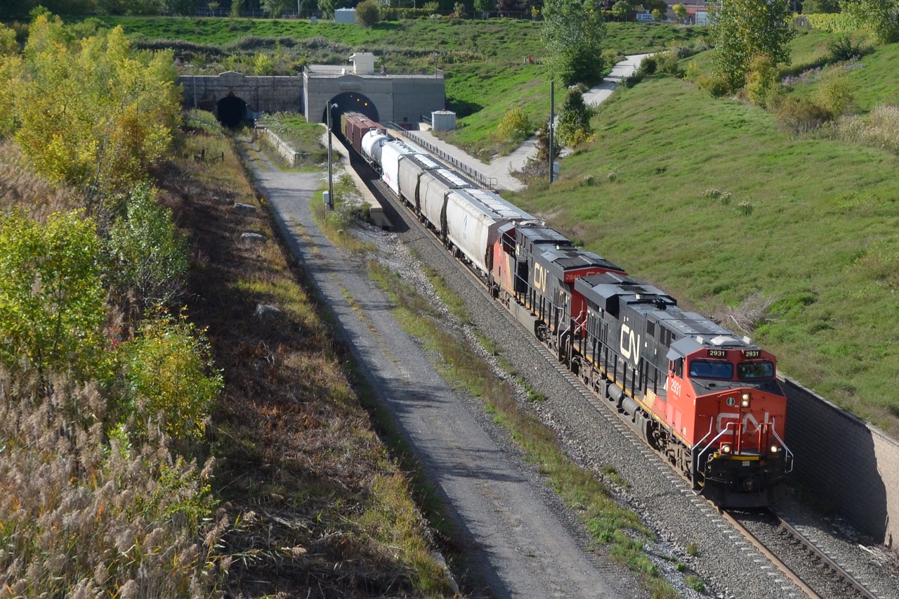 For my time machine shot, CN M398 exits the Paul M. Tellier International Tunnel in to Sarnia yard. I'm comparing my shot to Bill Thompson's 23 years ago  http://www.railpictures.ca/upload/canadian-nationals-st-clair-tunnel-at-sarnia-was-too-small-to-handle-higher-cars-such-as-double-stacks-so-the-decision-was-made-to-bore-a-new-larger-tunnel-a-special-ceremony-was-held-on-septemb . What has changed in 23 years? To handle traffic and to stay in the market, and new tunnel was bored to handle higher cars such as double stack intermodals.