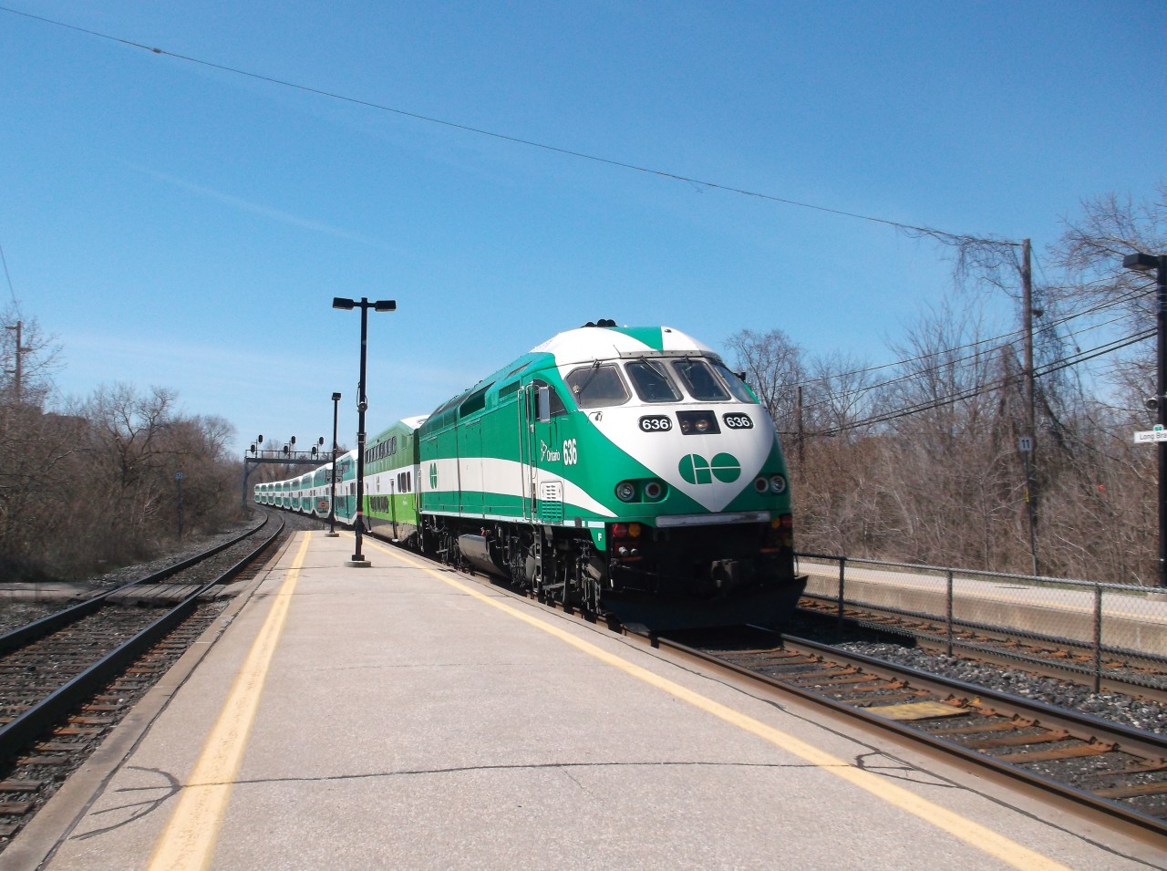 GO Transit MP40PH-3C #636 pulls into Long Branch GO station with an eastbound GO train bound for Oshawa.

#636 is one of 67 MP40PH-3C locomotives on GO Transit's fleet.  It was built in 2009 and the MP40PH-3C is GO Transit's newest locomotive, which was purchased to replace its ageing F59PH fleet.

GO Transit operates double deck coaches, which are built by Bombardier.  The entire fleet (locomotives and coaches) are being repainted in a new paint scheme, which is demonstrated on the first coach.

Long Branch station opened in 1967 as part of GO Transit's Lakeshore Line, which was the first line to be operated by GO Transit.