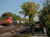 <b>Railfans at the end of the platform.</b>CN 377 with CN 2941 & CN 3087 heads west through Dorval as railfans get their shots. Of note is that CN 3087 is the 1000th unit built at GE's fairly new plant in Fort Worth, Texas.