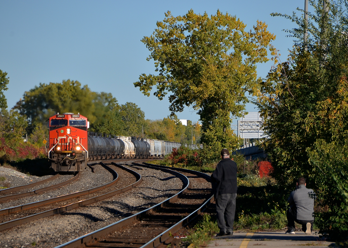Railfans at the end of the platform.CN 377 with CN 2941 & CN 3087 heads west through Dorval as railfans get their shots. Of note is that CN 3087 is the 1000th unit built at GE's fairly new plant in Fort Worth, Texas.