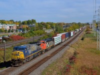 <b>Two uncommon GE models.</b> CN 327 is heading west through Pointe-Claire on CN's Kingston Sub, powered by two locomotive models that were not produced in large numbers. Leading is AC600CW CSXT 661, a model of which only 207 were produced and trailing is another GE product, Dash 8-40CM CN 2405, a Canadian-only model which saw a production run of only 84 units.