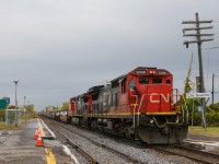 On a dreary morning, CN 106 is in all way from the west coast with standard cab CN 2008 leading CN 2632 as it passes the VIA Dorval station. Normally there is a fence between the two tracks here but it has been removed temporarily while trackwork is occurring.