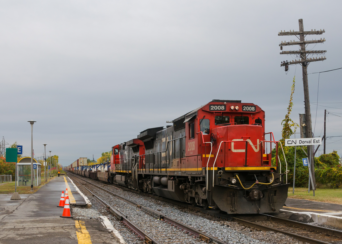 On a dreary morning, CN 106 is in all way from the west coast with standard cab CN 2008 leading CN 2632 as it passes the VIA Dorval station. Normally there is a fence between the two tracks here but it has been removed temporarily while trackwork is occurring.