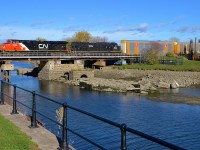 <b>Remains of the old swing bridge.</b> CN 2286 & IC 1026 lead a short (70 cars) CN 401 over the Lachine Canal on an afternoon where Montreal saw sun after many days of rain. The train is passing over the supports that held a swing bridge before the old bridge was replaced during the early 1990s. Every fall the canal is partially emptied, allowing the remains to be seen.