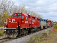 A CP switcher is parked on the Seaway Spur on the South Shore of Montreal with three GP38-2's for power. While the first and last units are common CP GP38-2's (CP 3053 & CP 34048), the second unit is DH 7303, one of only two units on CP's roster wearing the D&H lightning stripe paint scheme.