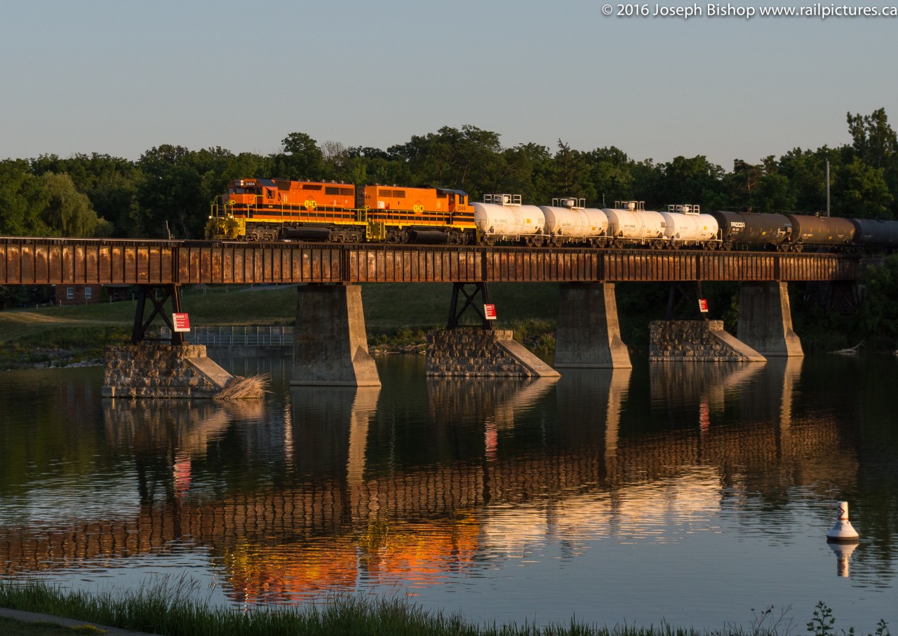 RLHH 3404 and RLHH 3049 lead an early running SOR 597 through Caledonia on the longest day of the year as the almost perfectly calm Grand River produces a nice reflection.