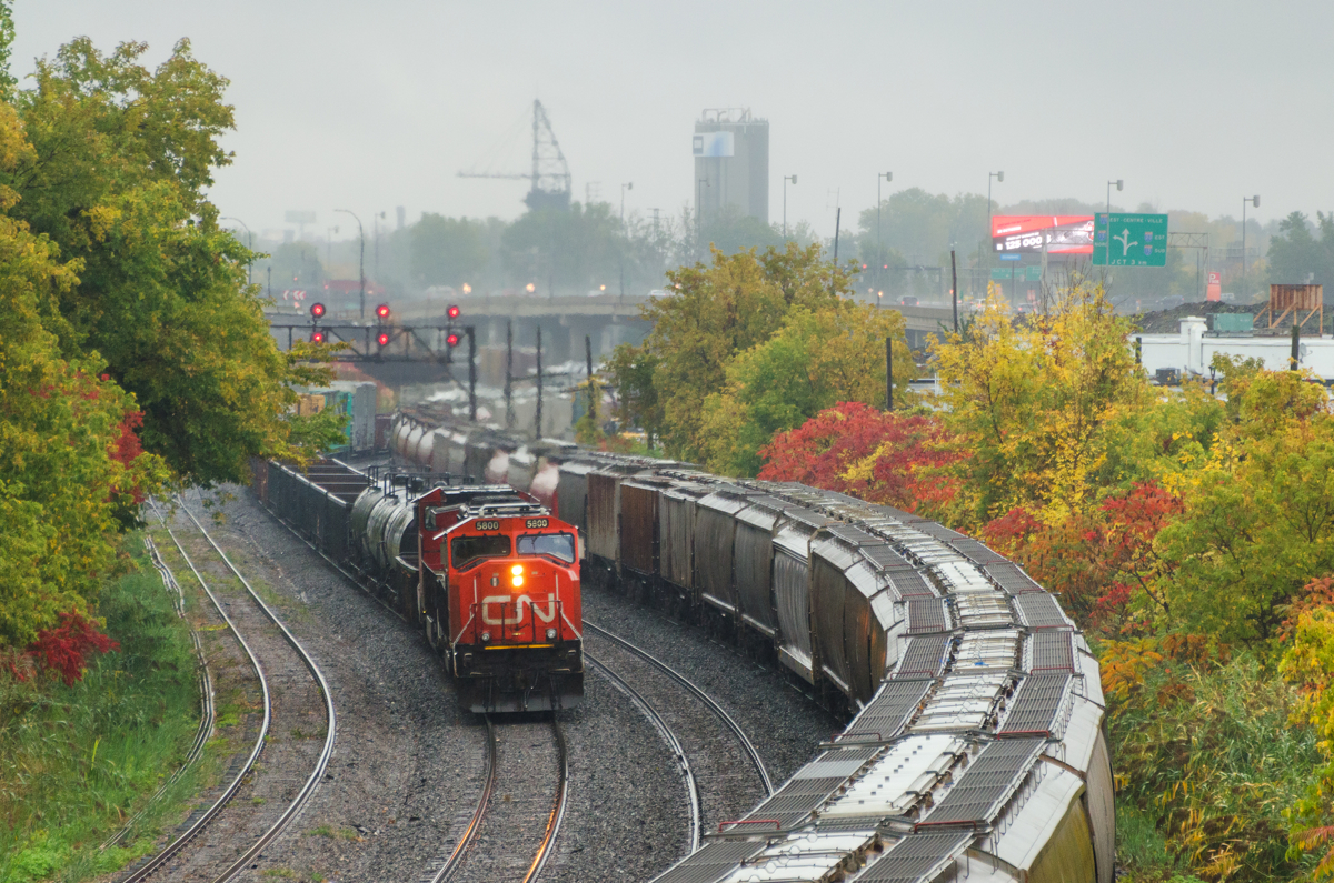 A pair of trains in the rain. As the rain falls, CN 527 is about preparing to back up and set off some cars at Turcot West, with CN's last SD75I (CN 5800) leading. At right grain train CN 874 is awaiting a new crew before heading east.