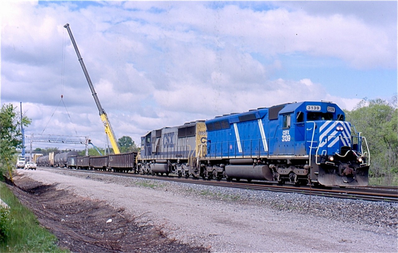 The mid 2000s were a busy and interesting time for the area I considered as the "funnel", this is CN's tracks between Burlington West and Bayview Jct. At this time CN was busy installing the new third track as well as eliminating the plant at Aldershot West in favour of a new plant a mile west called Snake. This extended the ladder track at Aldershot yard by around a mile to the west. In this photo power hungry CN has borrowed a pair of units off CSX to power train 390. The CEFX SD40-3 was originally a SP SD45, while the trailing CSX unit is a SD50. The crane in the background is carefully removing the signal bridge that protected the now eliminated cross overs at Aldershot West. In the foreground is the road bed for the new third track.