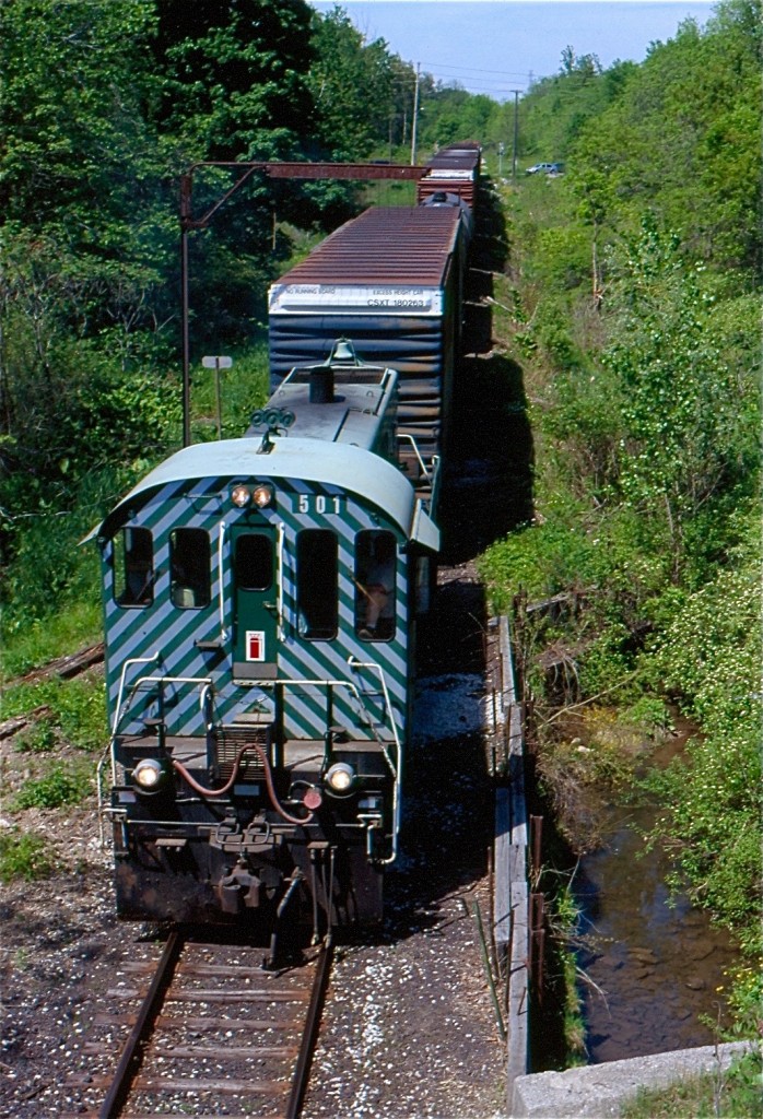 While OSR S-13 #502 started the days train, mechanical issues would force sister former BC Rail unit 501 to finish out the day's chores. Here we see 501 about to duck under the abandoned Canada Southern line as it heads for Tillsonburg yard and later the Trillium interchange. The abandoned CNR Burford sub. parallels the line here to the right. The 86' auto parts cars have since vanished from the area, but at the time of the photo auto parts were still produced in town.