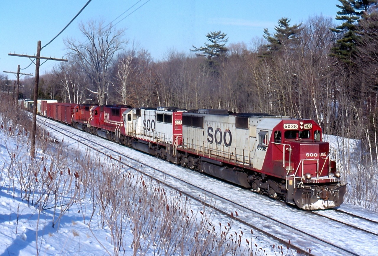 The growl of a quartet of EMD's hangs heavy in the air as three SOO Line SD60s and a lone CP SD40 claw at the grade up the Niagara Escarpment as they approach Guelph Junction, on cold but clear winter day.